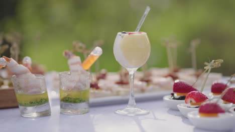 Cocktails-Und-Vorspeisen-Im-Fingerbuffet-Im-Freien,-Nahaufnahme-Eines-Tisches-Mit-Glas-Und-Köstlichen-Snacks